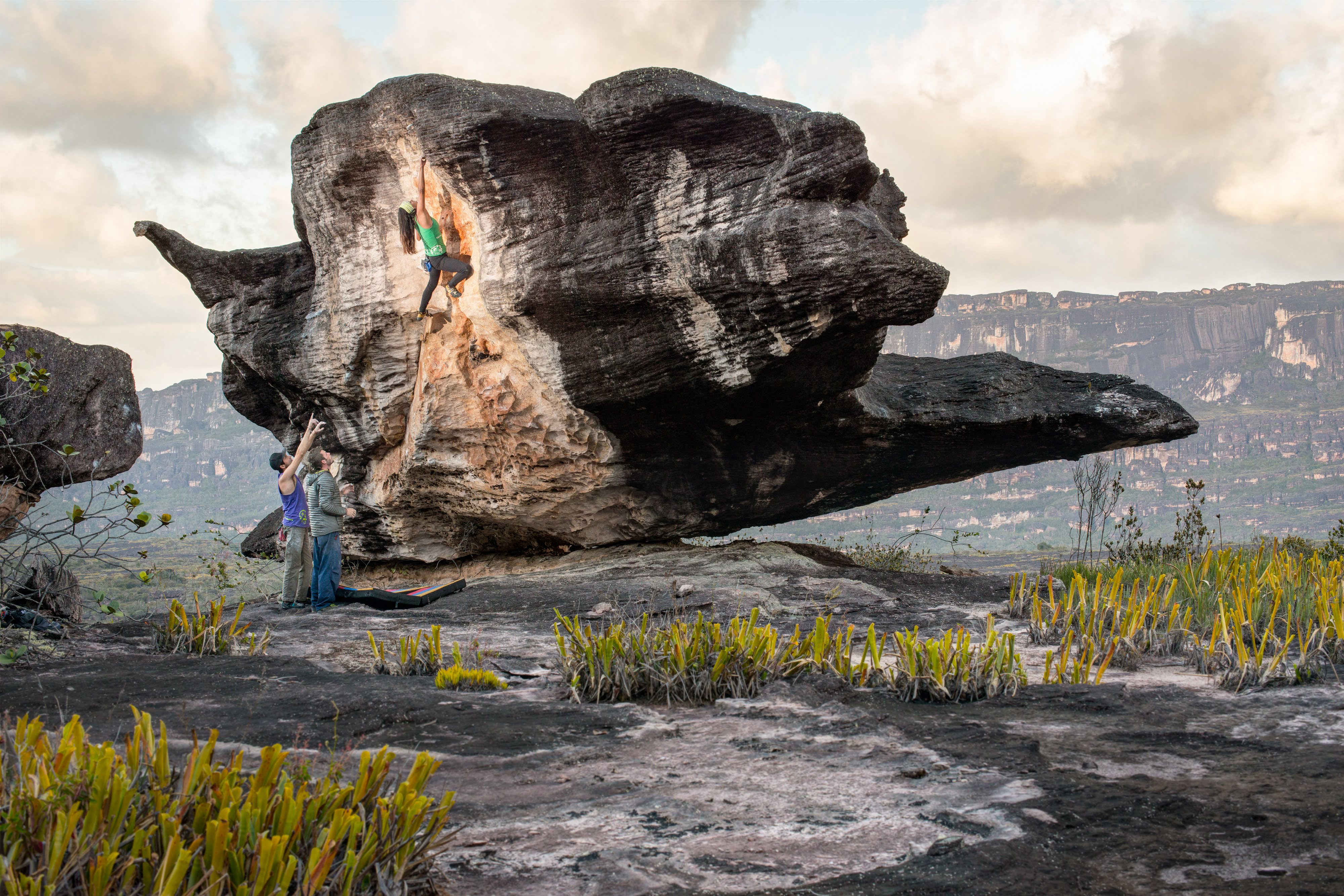 A climber on a mushroom-shaped boulder on the summit of Auyán-tepui